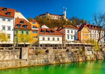 Prédios antigos na margem do rio Ljubljanica e castelo de Ljubljana, na Eslovénia